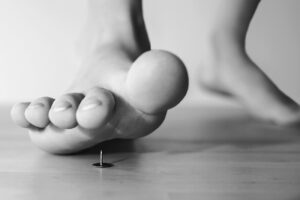 Piede che calpesta una puntina